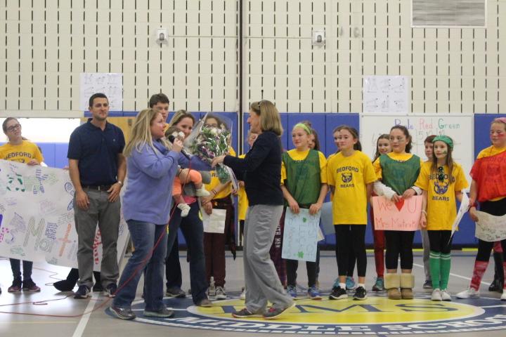 Mrs. Martinik being recognized with a surprise ceremony at a “Blue and Gold” game.