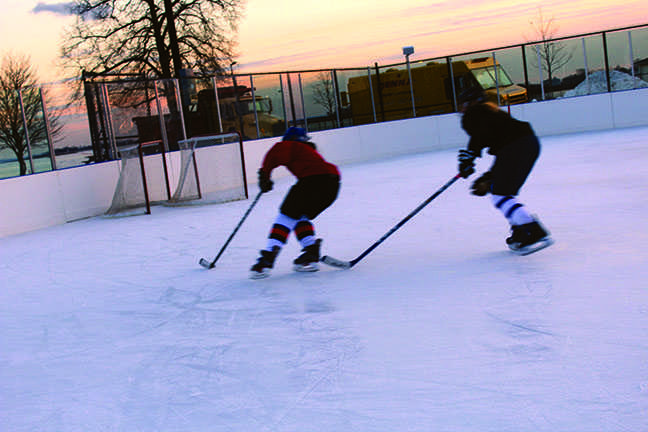 Two skaters from the Staples, Westhill, and Stamford High Schools combined girls’ varsity hockey team work to perfect their technique as the sun sets over the Sound.