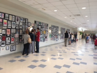 Students and their families gaze art work on display throughout the hallways.