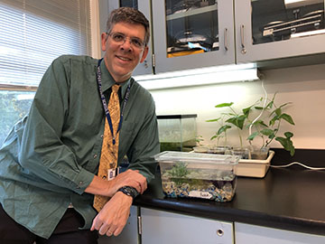 Dr. Dan Cortright stands next to the aquarium that held Bubba, a beta fish