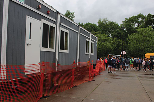 Arrival of the portable classrooms in the bus loop and off of the gym is part of the preparations for the next school year.