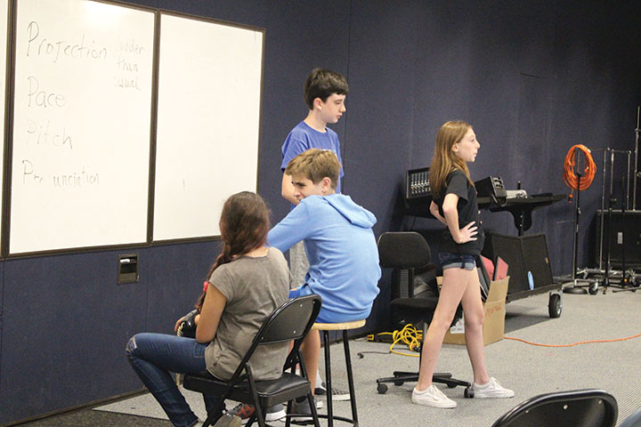 Cast members practicing one of the songs in a musical set in the rockin’ 50s. 