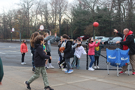 Sixth graders rush to get what they need for four square and basketball from security personnel Mr. Jason Intrieri.